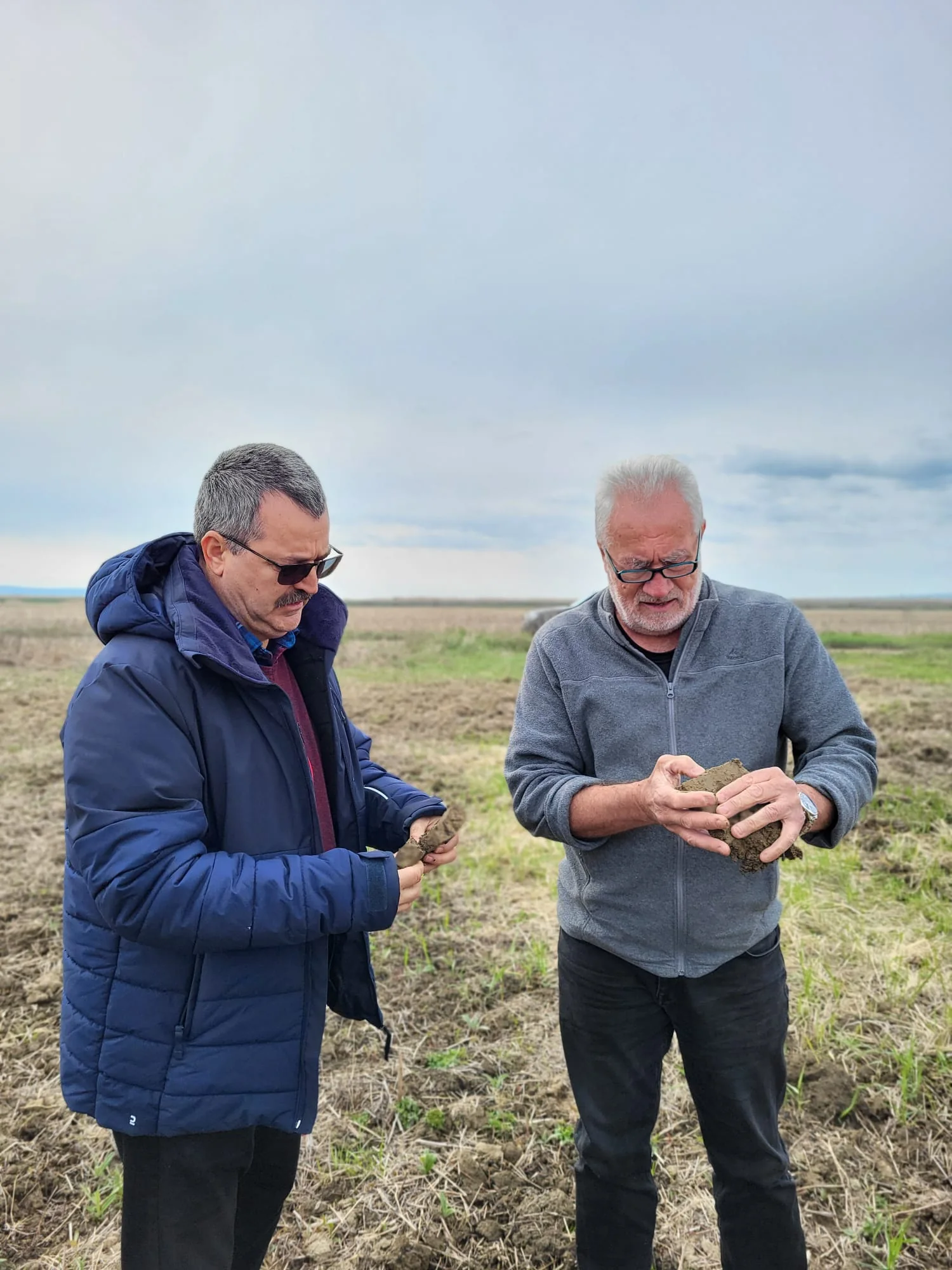 Adelin Morarasu and Alexandru Vulpe examining soil together at Orbeni
