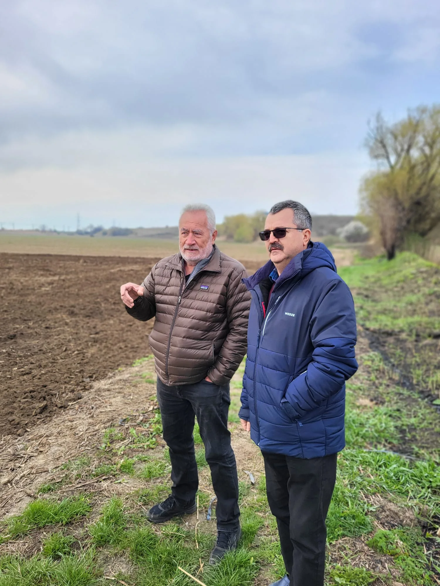Alexandru Vulpe and Adelin Morarasu standing together beside the land at Orbeni