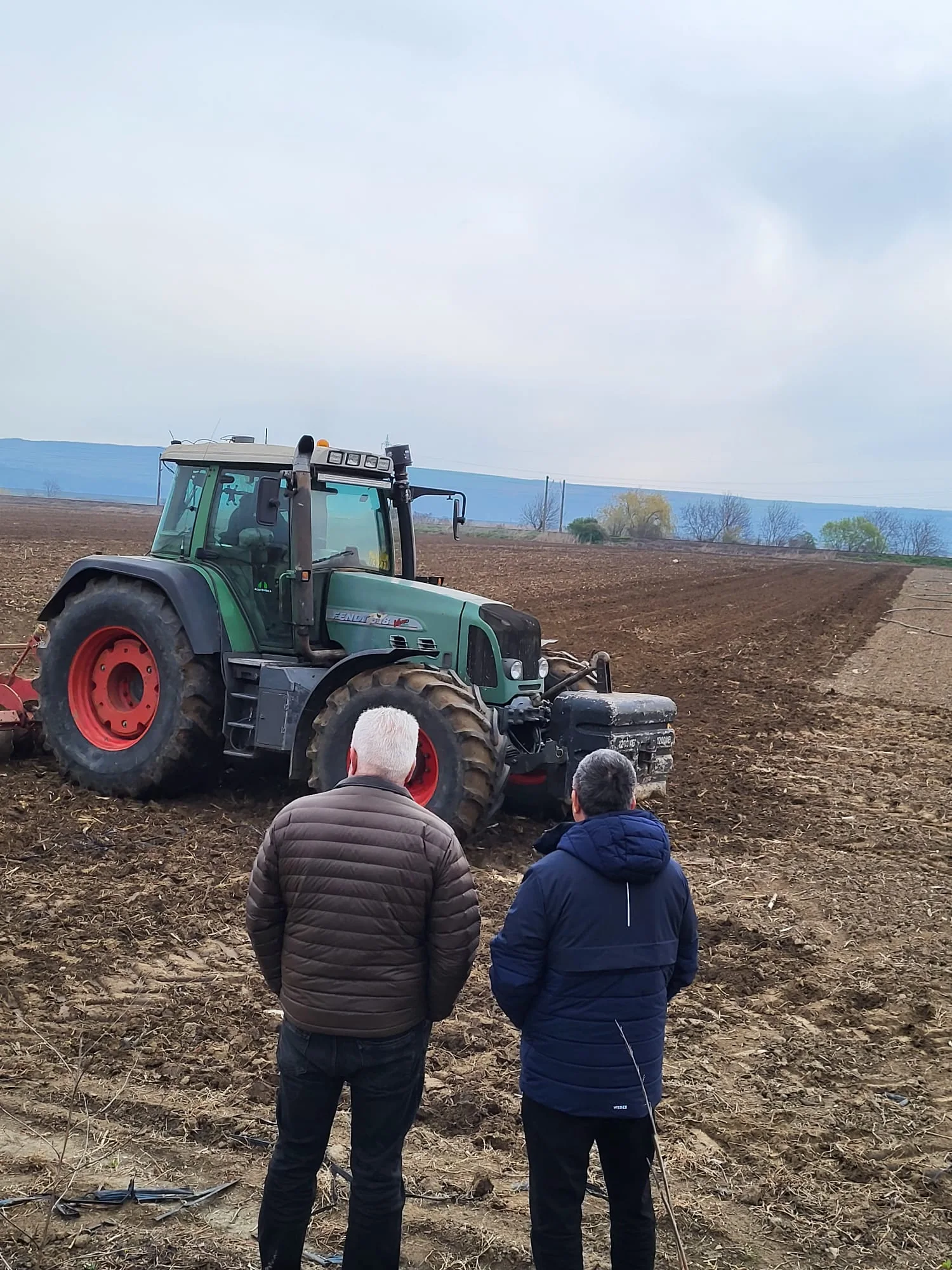 Adelin Morarasu and Alexandru Vulpe viewing a tractor in an Orbeni field